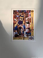 Front side of the card showing Magic Johnson of the Los Angeles Lakers defending Michael Jordan of the Chicago Bulls during a game. Card title is Magic vs Jordan and logo for Lakers vs Bulls is on the right side.
