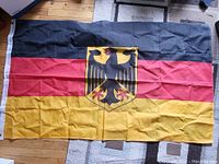 Full view of the large Germany flag laid flat showing colors and coat of arms in center