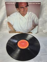 Photo of the black vinyl record with red label showing the album and artist details.