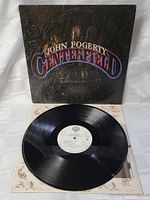 Vinyl record partially removed from sleeve, showing white label and condition of vinyl surface.