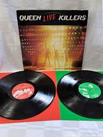 Front cover of Queen Live Killers album with two vinyl records placed inside red and green inner sleeves.