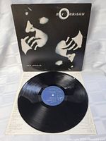 Vinyl record with blue center label and album cover featuring black and white image of Roy Orbison's face and hands.