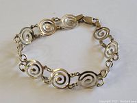 Close-up view of the sterling silver bracelet showing spiral design on links and clasp.
