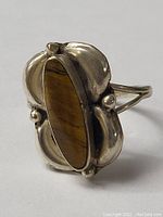 Close-up front view of the sterling silver ring with elongated oval tiger's eye stone set in ornate silver bezel.