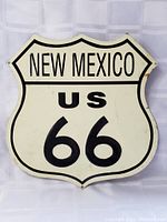 Front view of the vintage New Mexico US 66 metal highway sign showing its overall shape, colors, and condition.