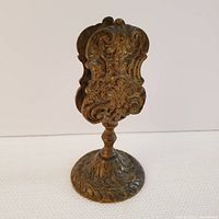 Front and side view of the ornate Art Nouveau style match box stand showing intricate scrollwork and shaped base.