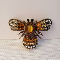 Front view of the bumblebee brooch showing detailed rhinestone setting and colors.