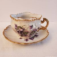View of the moustache tea cup and saucer with floral decoration and gold trim