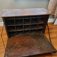 Open drop-down door revealing multiple cubby holes inside the secretary desk. Visible wear and wood grain details.