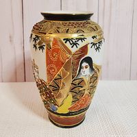 Front view showing a female figure in traditional robe with intricate gold and enamel decorations on the neck of the vase