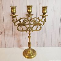 Front view of the candelabra showing three candle holders and foo dog decorative cut-out design.