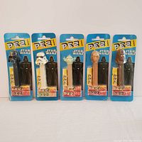 Front view of all five Star Wars PEZ dispensers in original 1996 sealed packaging.