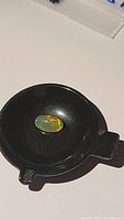 Opal in small black tray under light, showing overall shape and background contrast