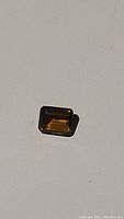 Deep cognac colored Madeira citrine gemstone, emerald cut, shown from different angles to display color and cut quality.