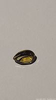 Close-up image of the pear cut citrine gemstone showing color and facets from side angle