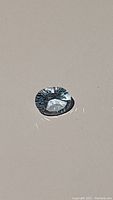 Natural sky blue topaz gemstone placed on a plain background showing cut and color.