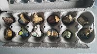 Set of 12 Wade animal figurines arranged inside an egg carton holder showing various species and colors.