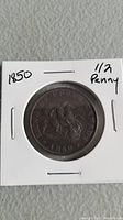 Front side of the 1850 Bank of Upper Canada half penny coin showing seated figure and date.