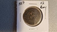 Front image of the 1857 Bank of Upper Canada half penny coin showing a mounted figure and date.