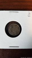 Front side of the 1913 Canadian 5 cent coin in a white cardboard holder with the date '1913' handwritten on the upper right corner of the holder.