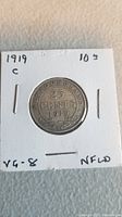 Obverse side of the 1919 Newfoundland 25 cent silver coin showing the denomination, year, and decorations.