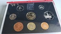 View of entire coin set in display case showing all nine coins and the 1995 emblem in the case.