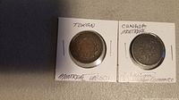 Two circulated metal tokens from Montreal, Canada, each mounted in protective cardboard holders with handwritten notes indicating 'Token', 'Canada Montreal', and references to agriculture and commerce.