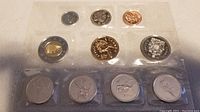 Photo showing 7 coins in clear protective sleeves, including special commemorative coins and standard Canadian denominations.