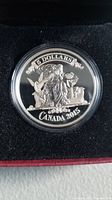 Reverse side of the coin showing a female figure gazing at a globe holding a winged disk, with '5 DOLLARS', 'CANADA', and '2015' inscriptions.