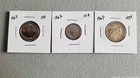 Three Canadian coins from 1967 in white 2x2 holders labeled 5¢, 10¢, and 25¢.