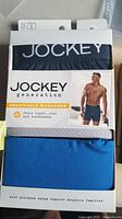 Pack of three pairs of Jockey boxer briefs in XL size, breathable microfiber fabric, unopened and showing color variety (navy, white, blue).