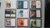 Nine Magic The Gathering cards arranged in a grid and sleeved individually