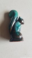 Blue Mountain Pottery ceramic squirrel figurine in sitting pose with curled tail, showing glaze color and details on neutral background.