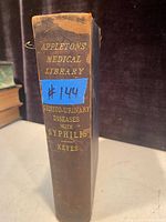 Spine of the antique book showing the title 'Appleton's Medical Library Genito-Urinary Diseases with Syphilis' by Keyes with visible age wear