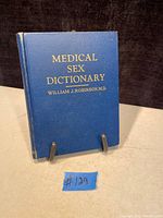 Front cover showing blue hardcover with gold embossed title and author name, minor wear visible.