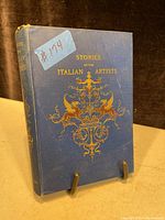 Front cover of the antique book showing blue hardcover with gold embossed title and decorative lions.