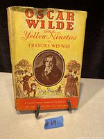 Front cover of the book showing the title and author with an illustrated portrait and period figures on a yellow and red dust jacket.