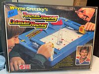 Box of Wayne Gretzky's Rocket Hockey game showing branding, images of the game in use, and photo of Wayne Gretzky