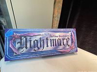 Box lid from the top edge showing graphic and game name 'Nightmare The Video Board Game'. The box shows minor wear indicating vintage condition.