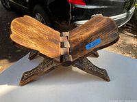 Open view of the wooden book holder showing its foldable construction and wood grain.