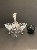 Front view of ornate sterling silver basket with cut crystal bowl and green apple for scale