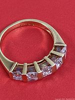 Ring viewed from top on red background showing five diamonds set in gold