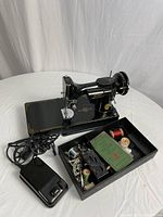 Singer Featherlite sewing machine body with foot pedal and accessories tray visible