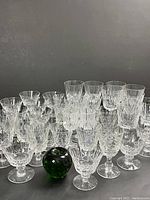 Front view showing 34+ crystal glasses and one green crystal apple for size reference
