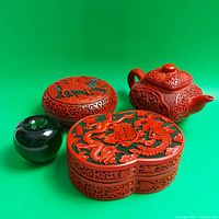 Group view of teapot, round box, oval box and reference apple