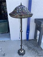 Full view of the floor lamp showing the stained glass shade and twisted metal base.