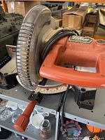 Side view of the chop saw showing handle, transparent blade guard, and angle measurement base.