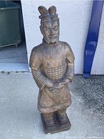 Front view of the terracotta warrior statue showing detailed armor, facial expression, and stance.