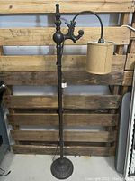 Full view of the floor lamp showing the base, pole, curved arm, and attached fabric lampshade.