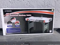 Image of the boxed Triumph 48" Overtime air powered hockey table showing front and side views on the packaging.